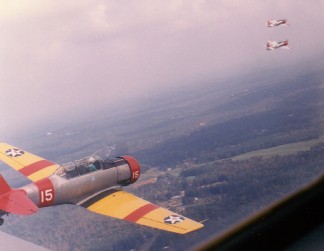 Milt Yarbrough in an SNJ, with a flight of T-34s in the background